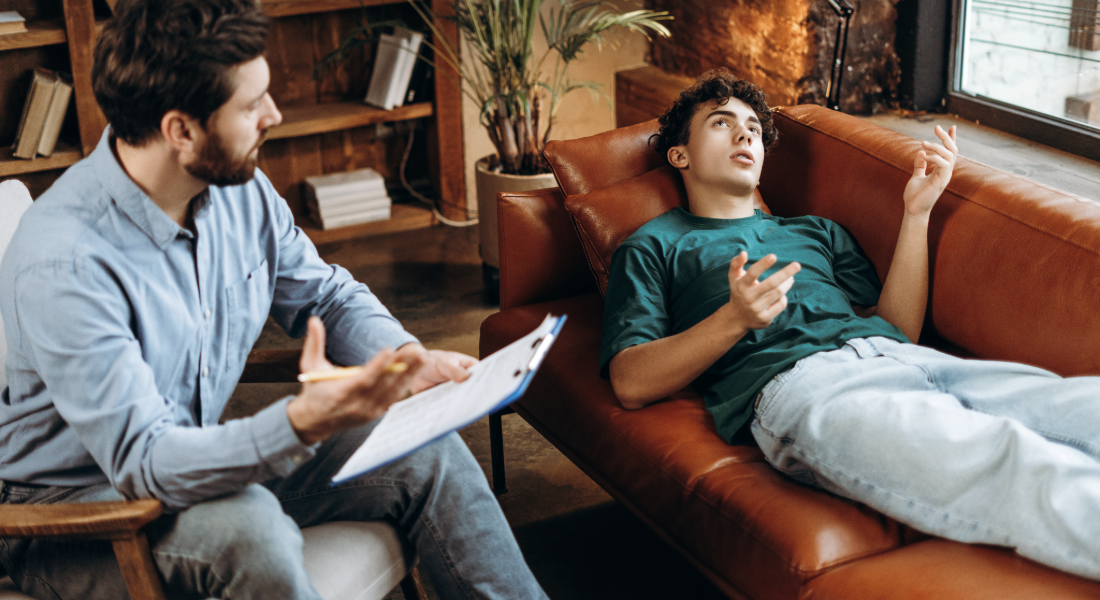 young man on a therapist couch talking to a therapist